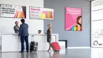 A man and woman with luggage at a check in desk