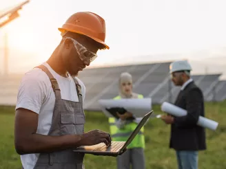 PV Solar power plant with technician on a laptop in the foreground