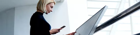 Woman using a phone and digital sign