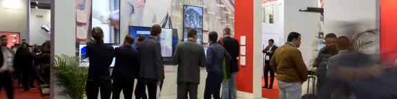 People gathered around BIG PAD interactive displays at ISE